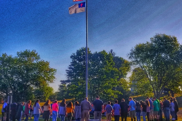 Students praying around the flag pole