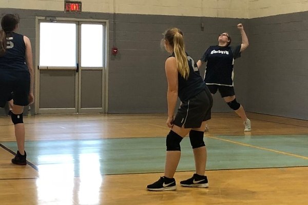 Female student serving volleyball