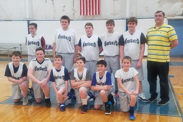 Boys basketball team standing and kneeling for group photo